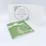 Προσκλητήρια γάμου με λουλούδια 20g020 ta green wreath dali, χαρτί ακουαρέλα, στεφάνι, πράσινες και λευκές αποχρώσεις με κορδέλα, της εταιρίας  NewAge invitations